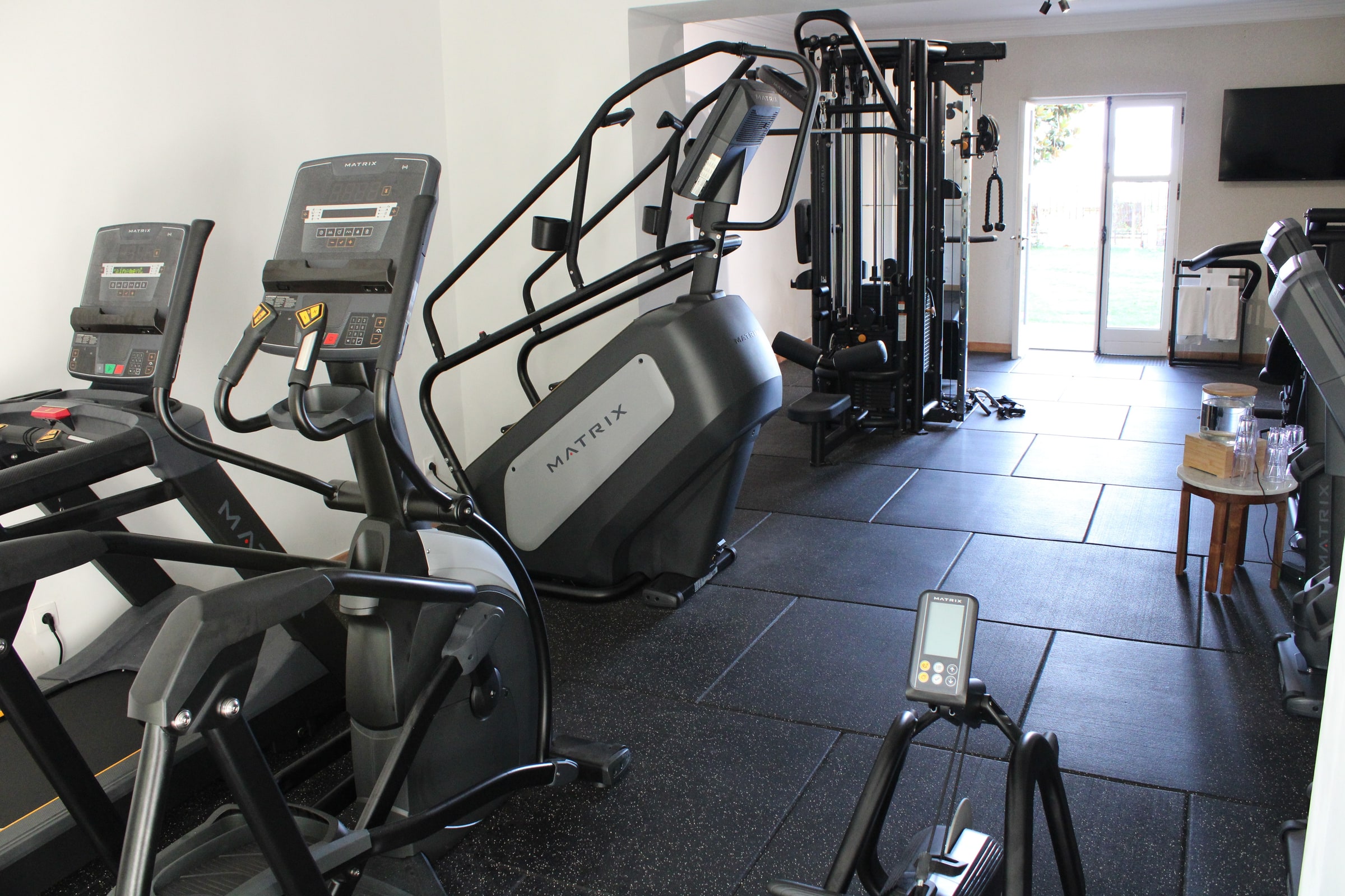Salle de sport de l’Hôtel A Storia ouverte sur les jardins et la piscine extérieure